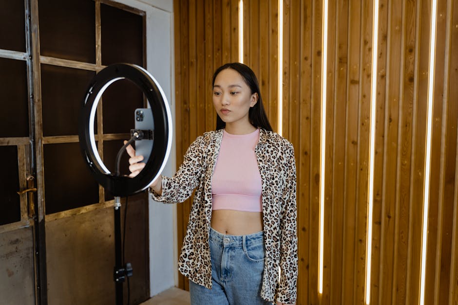 An asian woman influencer filming a vlog with a ring light in a stylish indoor setting.